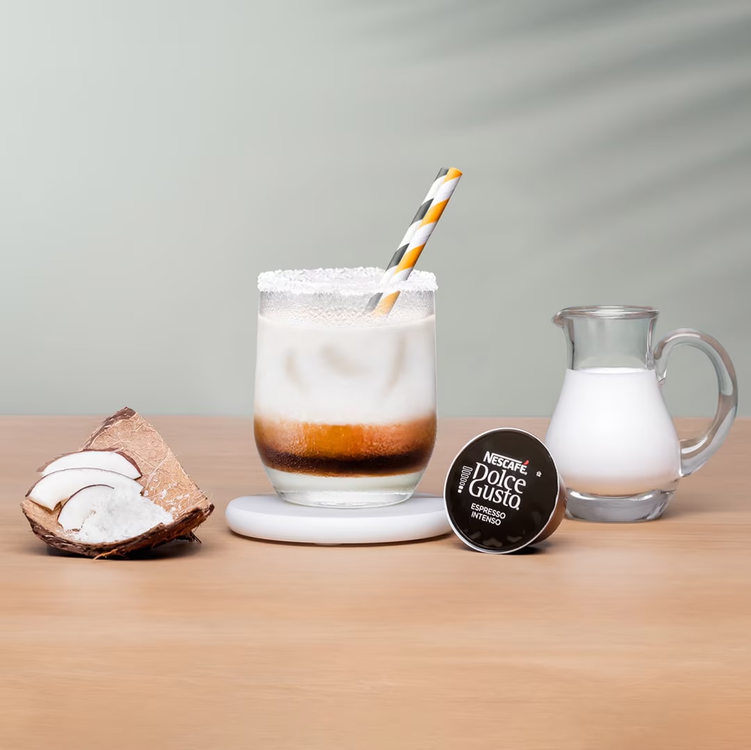 iced cappuccino next to a coffee capsule