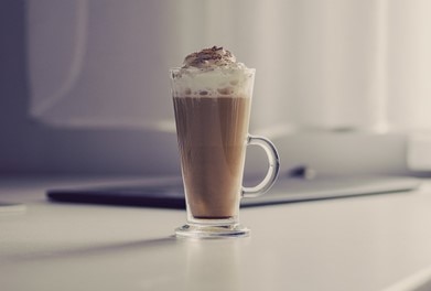 A latte with whipped cream and chocolate on top